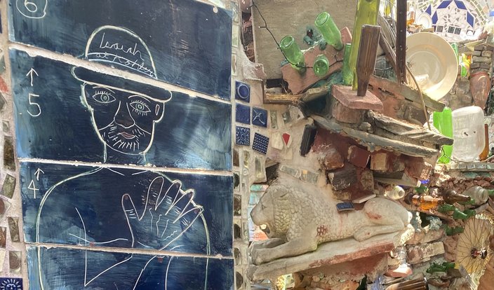 Portrait of a man in a hat with the text 'Isaiah' in the Magic Gardens sculpture garden of Philadelphia