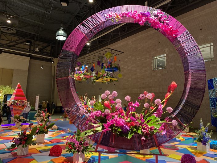 'Harmony in Geometry' display of pink and purple flowers on a circular structure