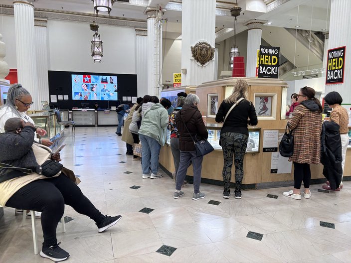 Customers browse a jewelry counter in a department store