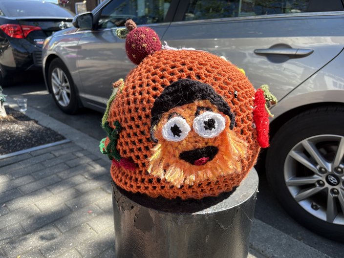 An orange knitted sphere with the face of Gritty, the Flyers' mascot