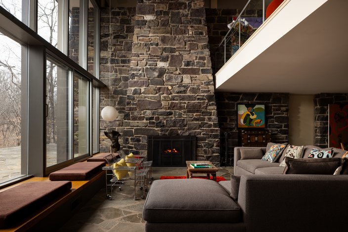 Living room with a stone fireplace and brown couch in Newtown, Bucks County