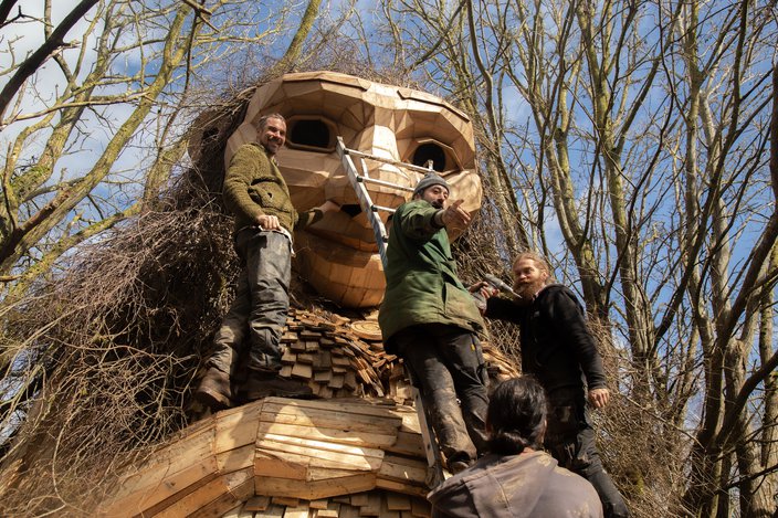 Thomas Dambo and three other builders work on a troll sculpture in Denmark