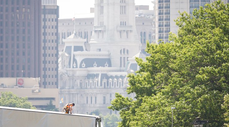 Carroll - A construction worker assembles a stage in hot weather for Wawa Welcome America