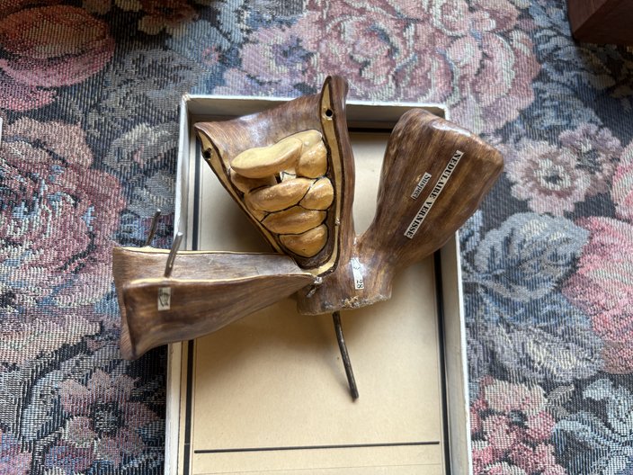 A brown and tan papier mâché mushroom dissembled into pieces.