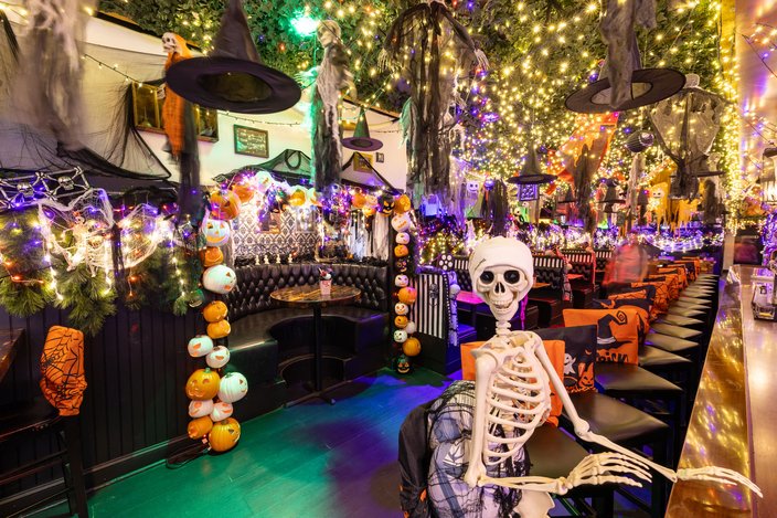 Bar with a fake skeleton, lights, pumpkins and other Halloween decorations
