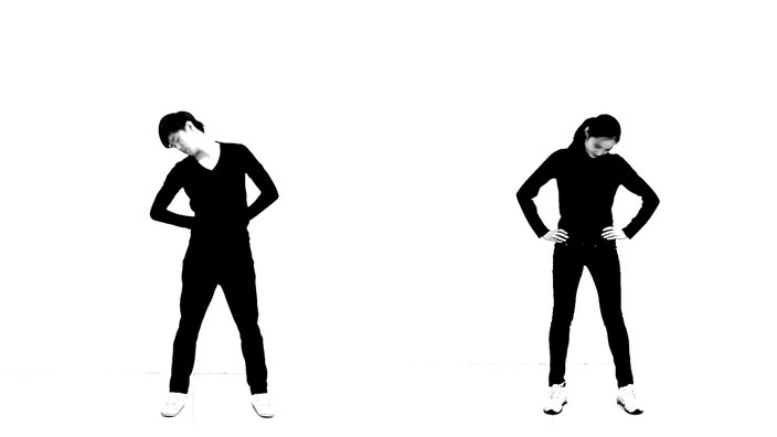 A black-and-white video still depicting a man on the left and a woman on the right doing exercises.