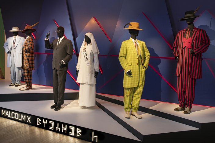 Suits and other costumes from the movie 'Malcom X' displayed on mannequins