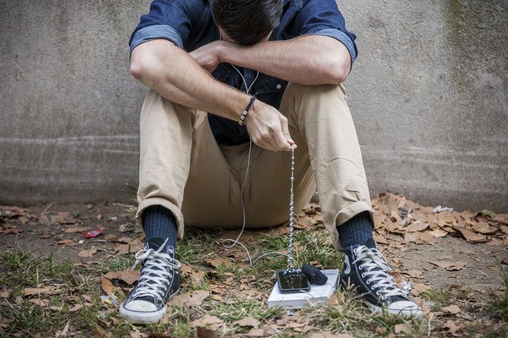 Carroll - Man praying with rosary beads