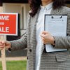 Home for Sale sign held by real estate agent