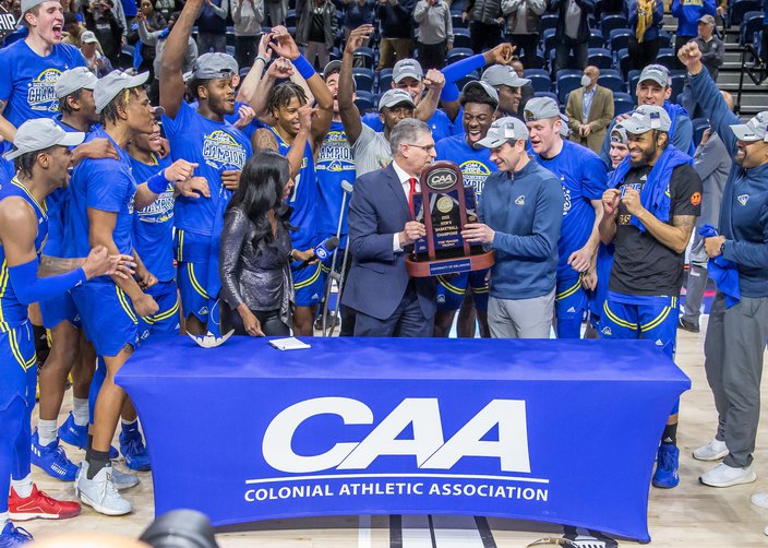 Martin Ingeslby and the Delaware Blue Hens celebrate winning the 2022 CAA Men's Basketball Tournament.