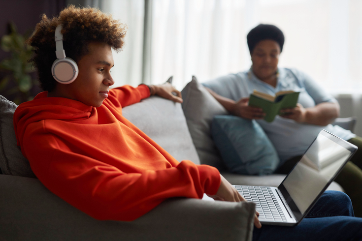 Purchased - Teen with laptop and mom in background