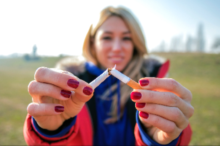 Woman breaking cigarette in half quitting