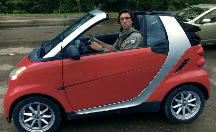 Adam Driver drives a smart car 