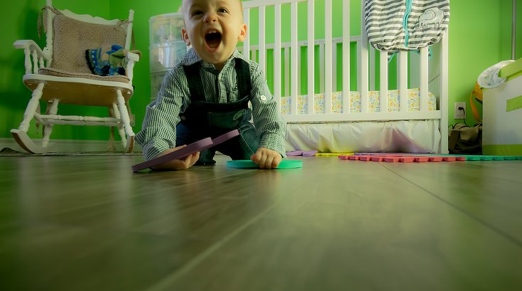 Toddler playing next to crib