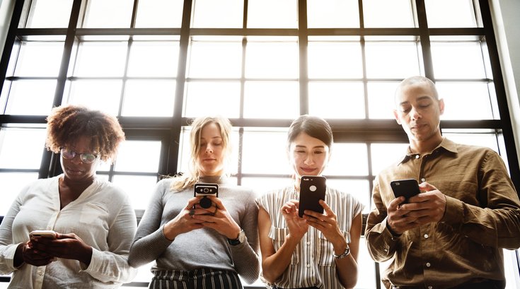 Four people using their smartphones