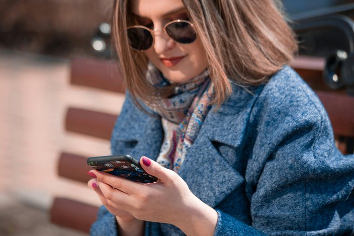 Woman in sunglasses looking at her phone