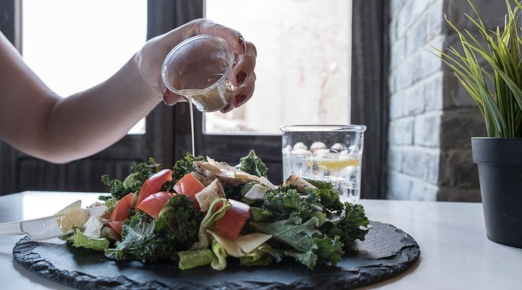 Pouring dressing on a salad