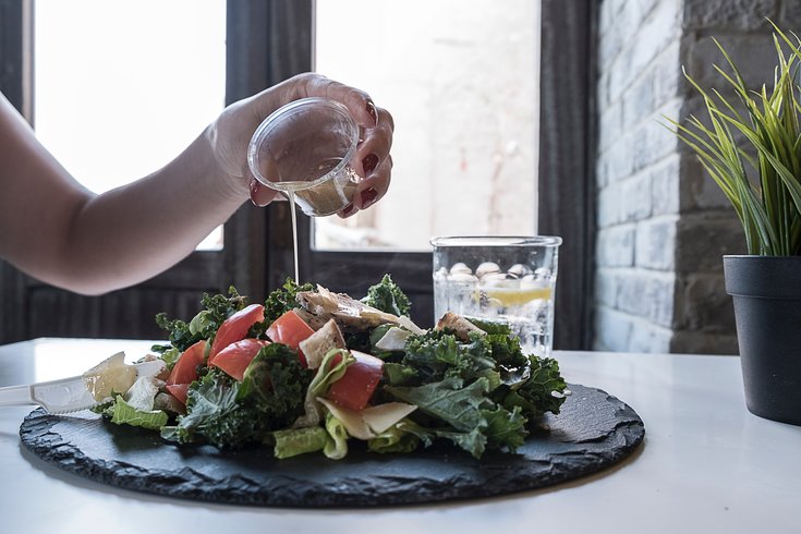 Pouring dressing on a salad