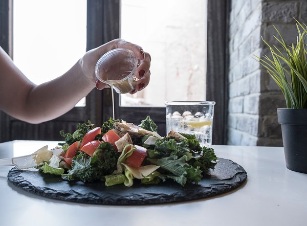 Pouring dressing on a salad