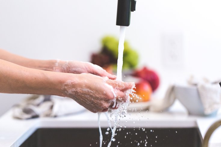 Person washing their hands in kitchen sink