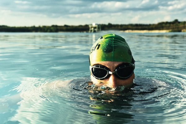 Man swimming in a lake with goggles