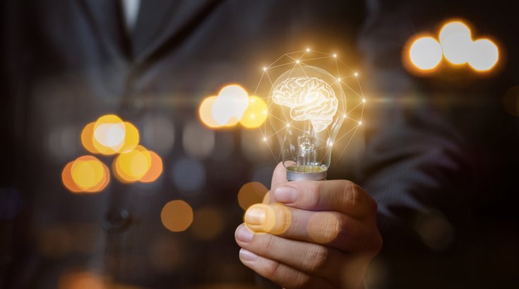 Man holding lightbulb brain power