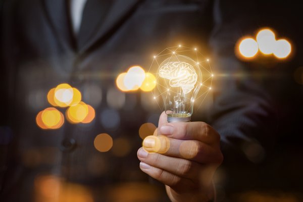 Man holding lightbulb brain power