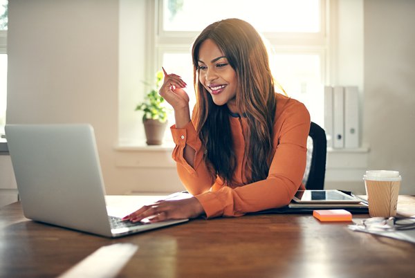 Purchased - Woman smiling at desk working from home