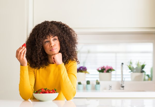 Purchased - Woman sitting at table eating fruit