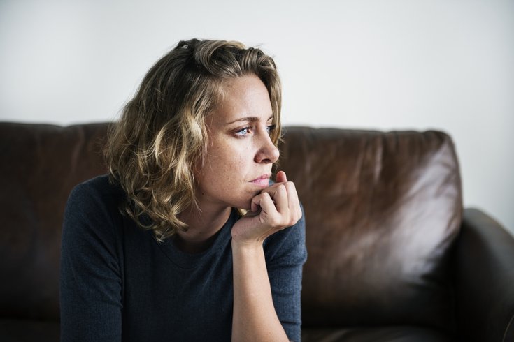 Woman deep in thought on a sofa