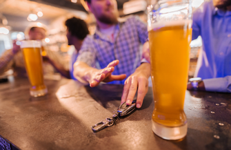 Limited - Man reaching for glass of beer and friend stopping him