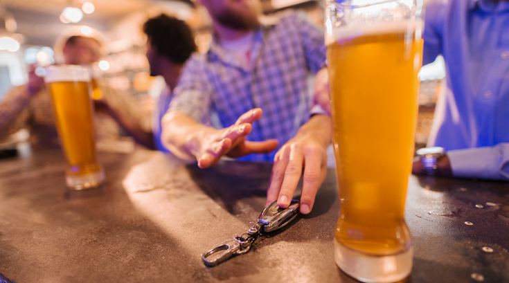 Limited - Man reaching for glass of beer and friend stopping him