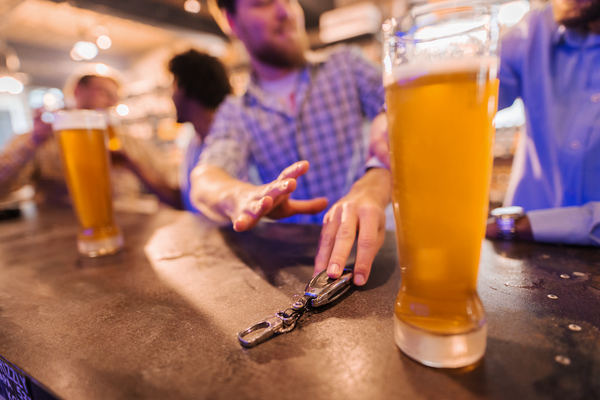 Limited - Man reaching for glass of beer and friend stopping him