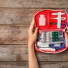 Holding first aid kit on wooden background