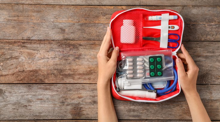 Holding first aid kit on wooden background