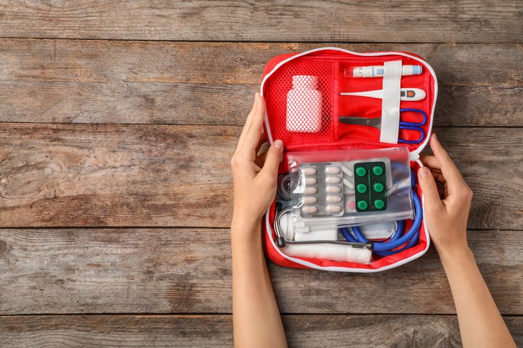 Holding first aid kit on wooden background