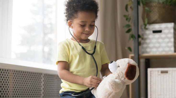 Boy playing doctor with stuffed animal