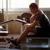 Man sitting on weight bench with injury