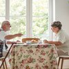 Elderly couple eating a meal at the kitchen table