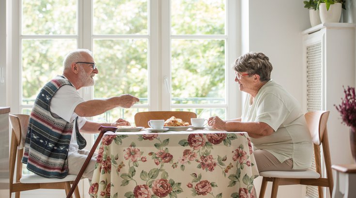Elderly couple eating a meal at the kitchen table