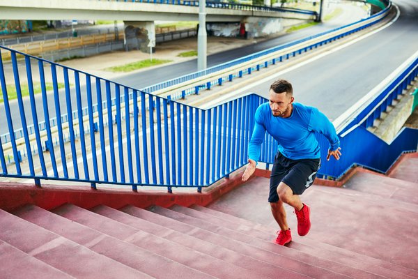 Purchased - Athletic man doing interval training running on stairs