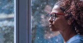 Purchased - Woman looking out a snowy window