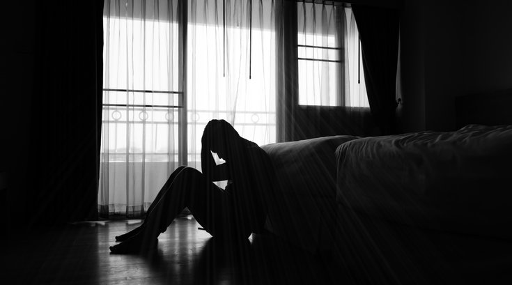 Purchased - A person sitting on the floor depressed