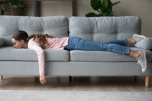 Limited - Young woman lying buried her face in sofa feels tired