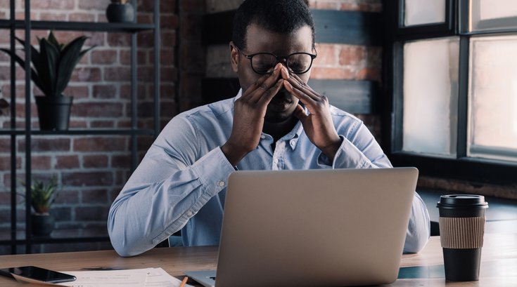 Purchased - Tired man sitting at his desk exhausted