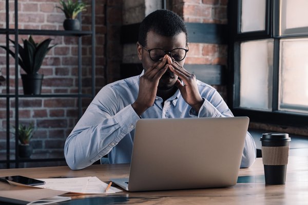 Purchased - Tired man sitting at his desk exhausted