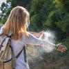 Purchased - Woman applying mosquito repellent on hand during hike in nature