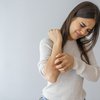 Woman scratching itch on arm