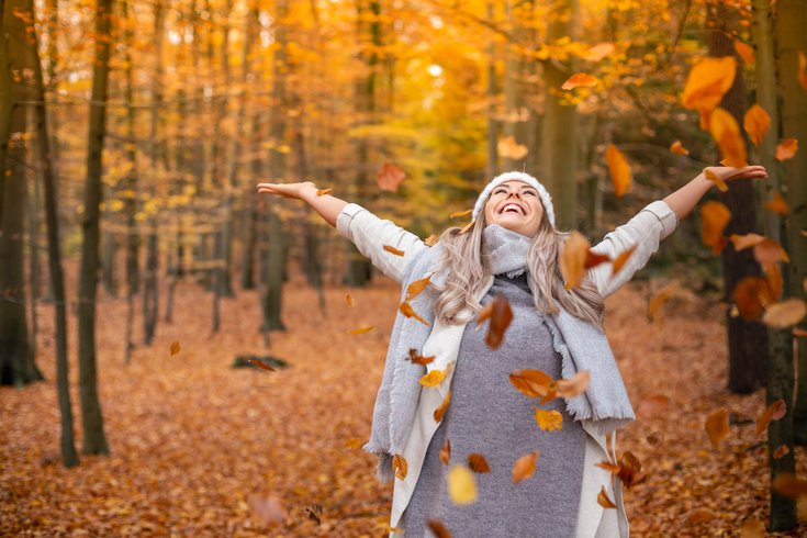 Happy Woman in Autumn leaves
