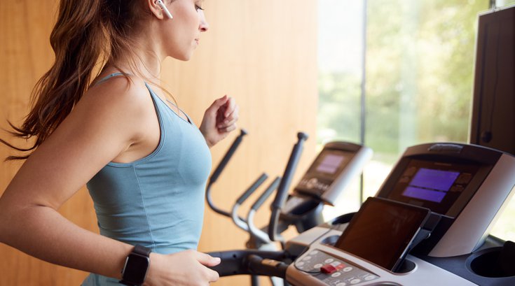 Purchased - woman running on a treadmill watching tablet and using phone